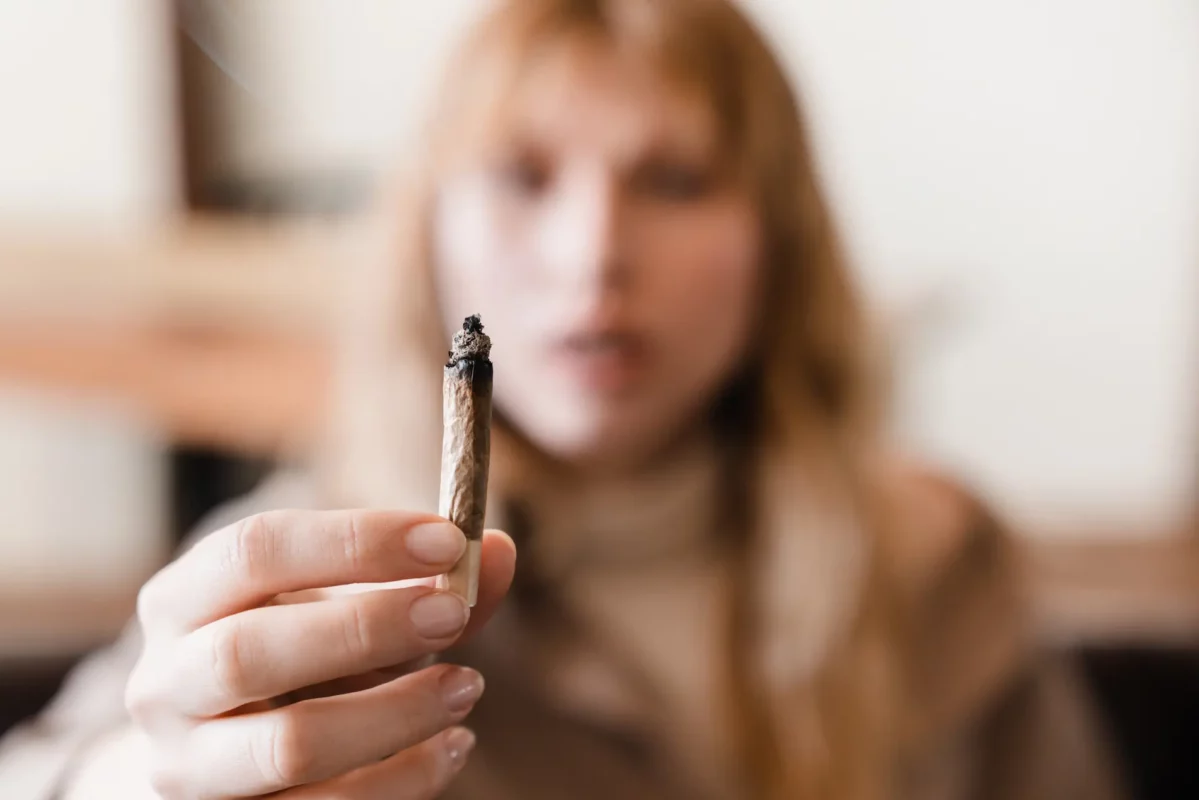 blurry depiction of a woman holding a joint